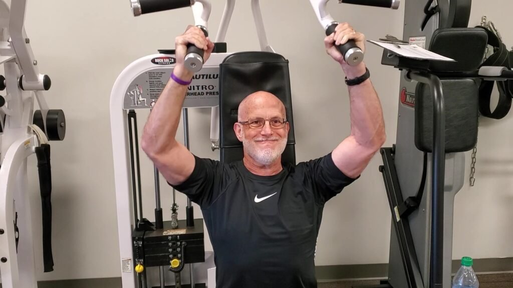 can flabby arms be toned after 60 - overhead shoulder press on machine to target the triceps muscle.